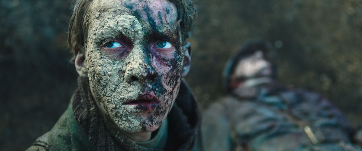 Half a German soldier's face is caked in dry, cracking mud in "All Quiet on the Western Front."