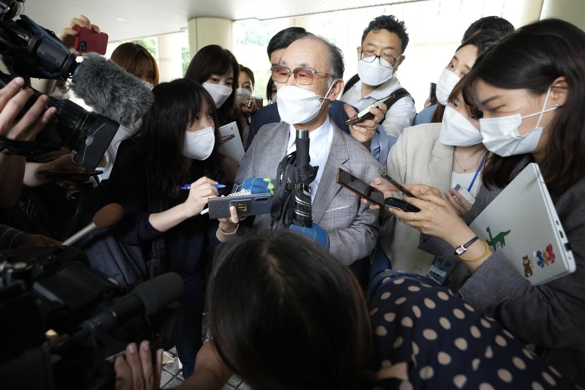 Lim Chul-ho, center, the son of a deceased forced laborer, speaks at the Seoul Central District Court in Seoul, South Korea, Monday, June 7, 2021. A South Korean court on Monday rejected a claim by dozens of wartime Korean factory workers and their relatives who sought compensation from 16 Japanese companies for their slave labor during Japan's colonial occupation of Korea. (AP Photo/Ahn Young-joon)
