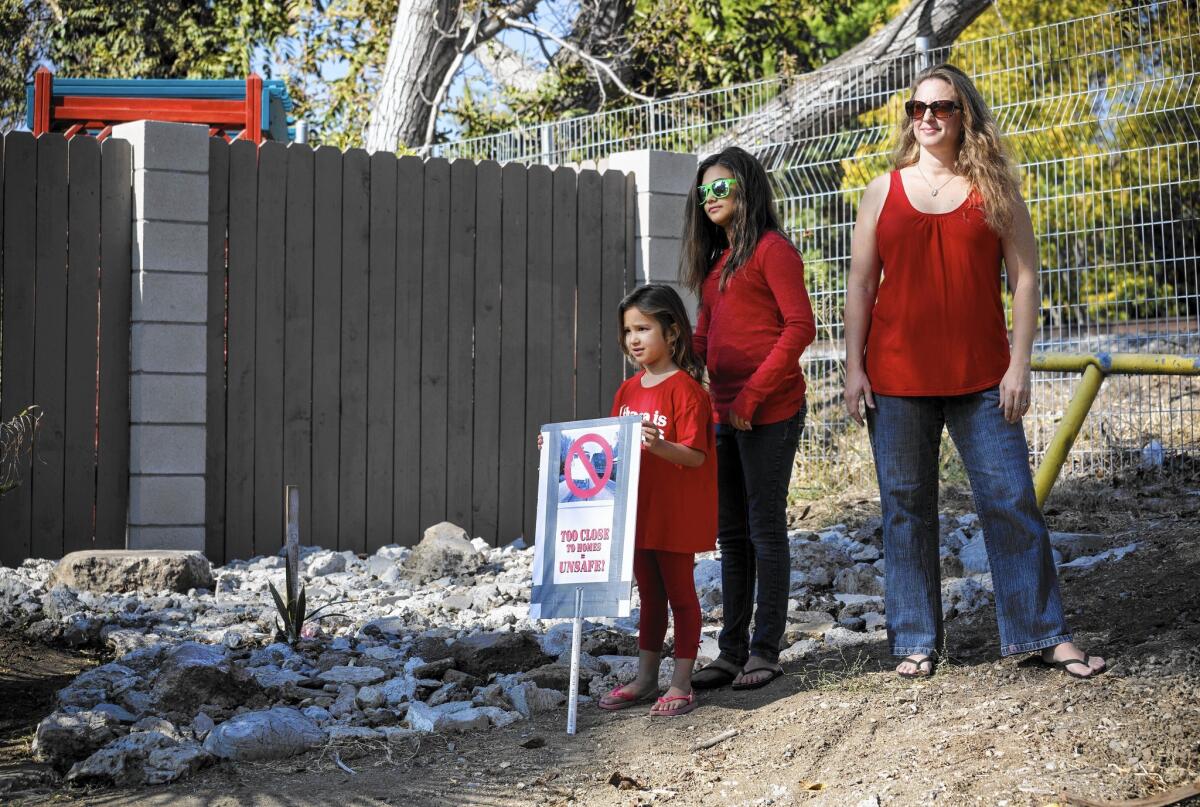 Leah Guardino, 5, left, her sister Ava and mother Briana oppose Metro's plan to build a new track on an existing right of way near their Northridge home. About 130 homes are directly adjacent to the tracks.