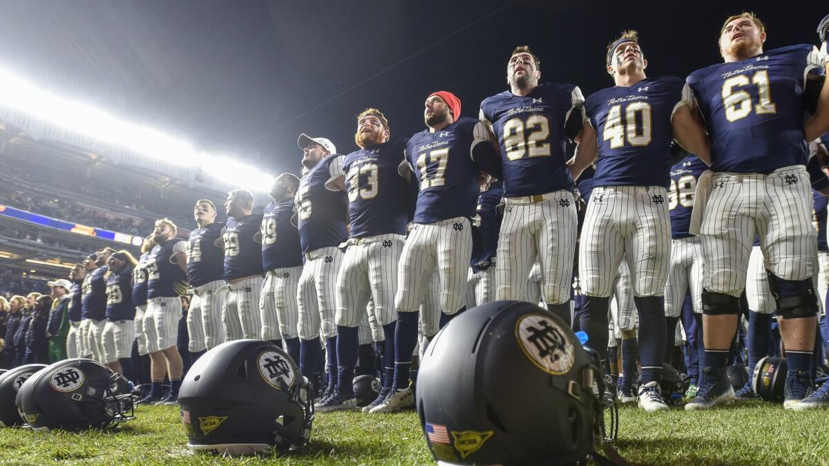 Notre Dame players line up at the end zone to greet fans and cheer with them after their game against Syracuse on Saturday at Yankee Stadium in New York.