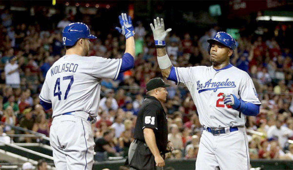 Ricky Nolasco high fives Carl Crawford after scoring in the fifth inning of the Dodgers' 6-1 victory over the Arizona Diamondbacks on Tuesday.