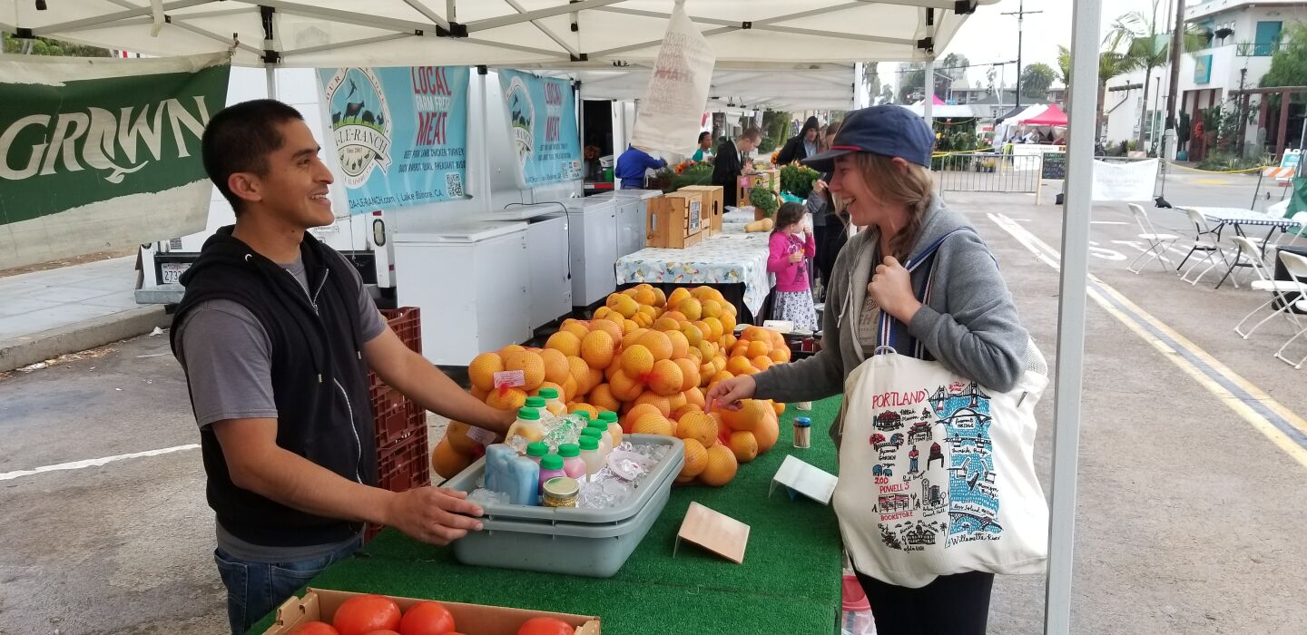 Carmelo Martinez of Heritage Family Farms sells grapefruit to Nina LiGreci.