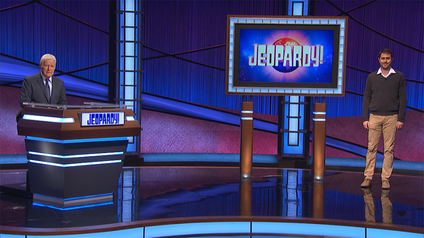 Costa Mesa resident Ben Lewis stands on the set of "Jeopardy!" along with host Alex Trebek.