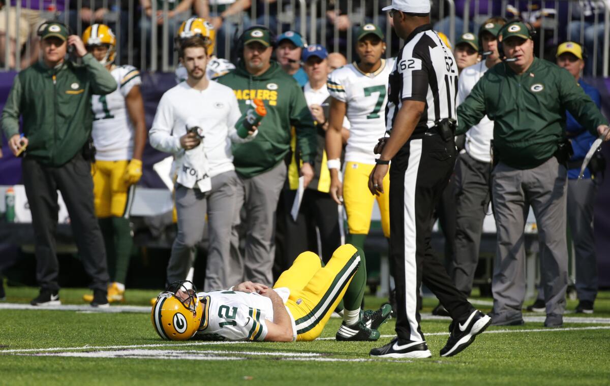 El quarterback Aaron Rodgers, de los Packers de Green Bay, queda tendido en el campo tras recibir un golpe del linebacker Anthony Barr, de los Vikings de Minnesota, en el juego de NFL en Minneapolis, el domingo 15 de octubre de 2017.