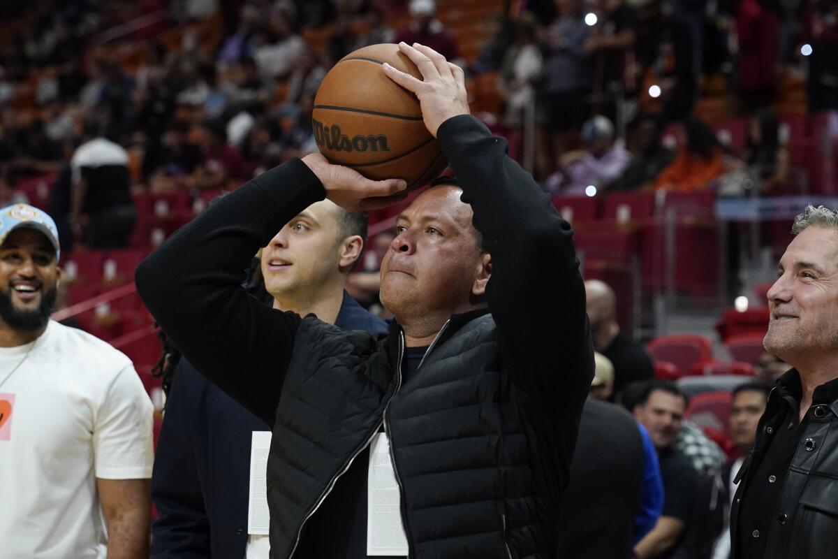 Alex Rodriguez, partial owner of the Minnesota Timberwolves NBA team aims a shot at the basket before the first half of an NBA basketball game against the Miami Heat, Saturday, March 12, 2022, in Miami. (AP Photo/Marta Lavandier)