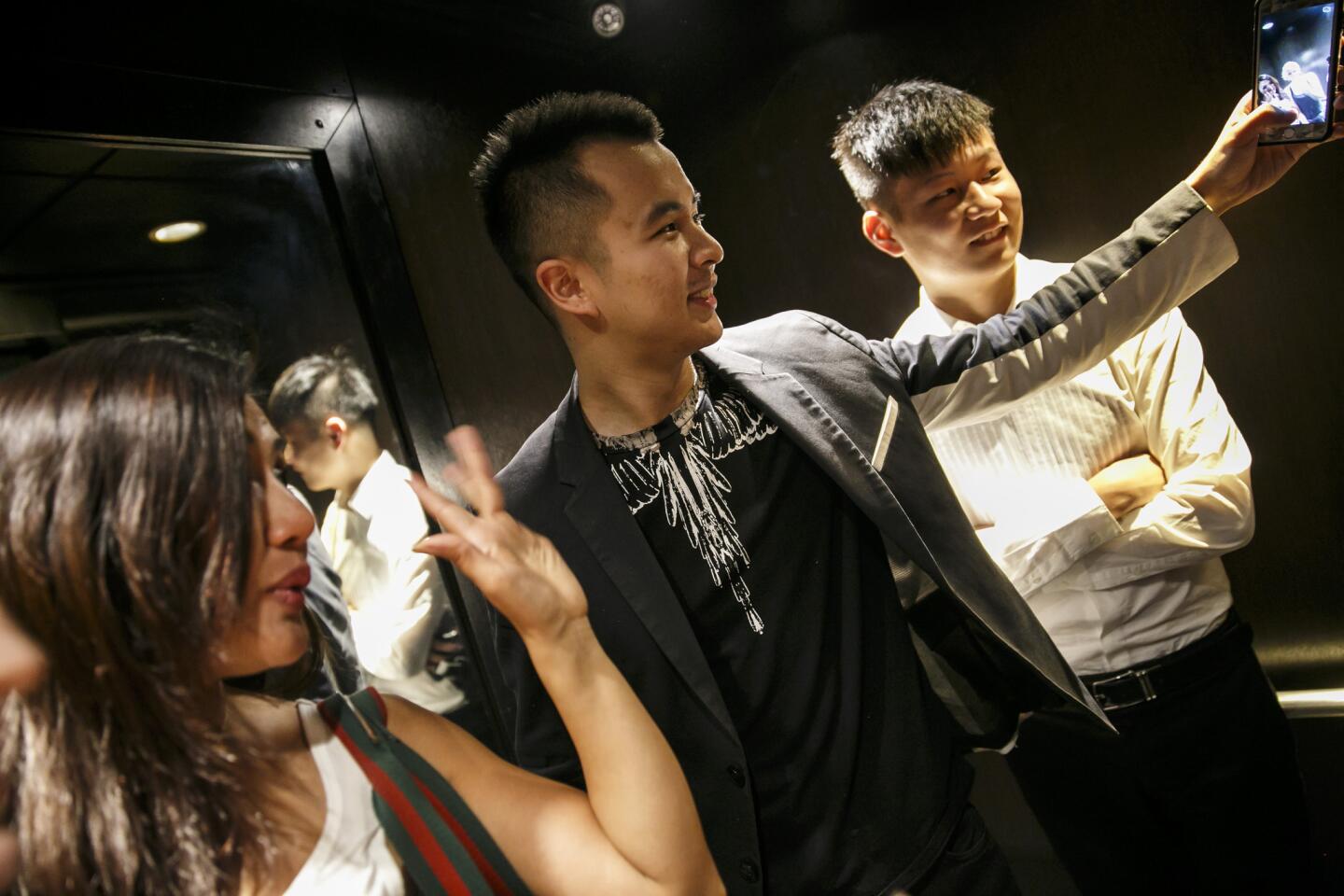 Rudy Rong, center, with Katharine Chen, left, and Kevin Chen, poses for a photo as they film for Rong's interactive virtual-reality startup in Los Angeles.