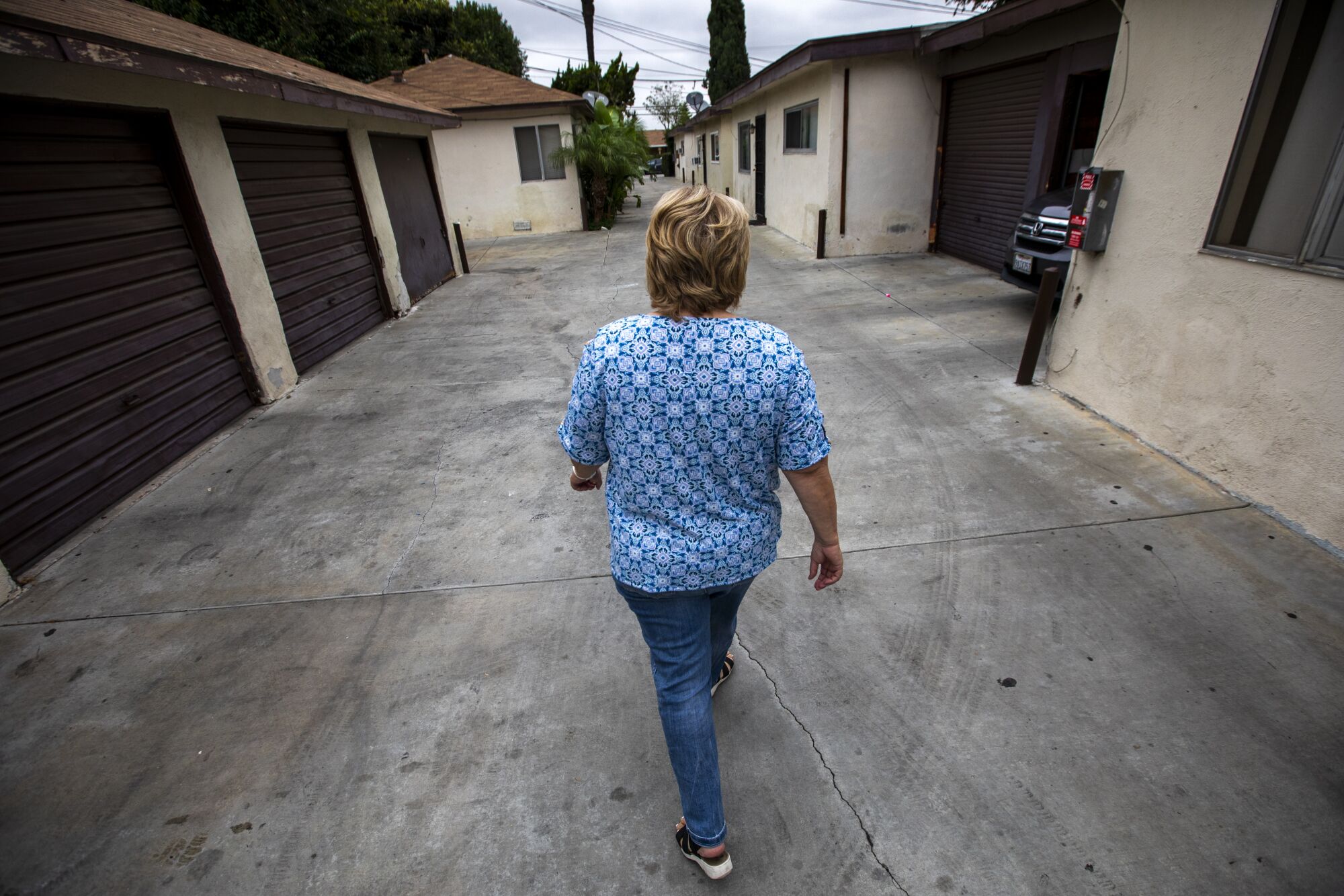 Cheryl Sanchez Simmons walks through the bungalow court in Lynwood where Jan Marsh lived with her family.