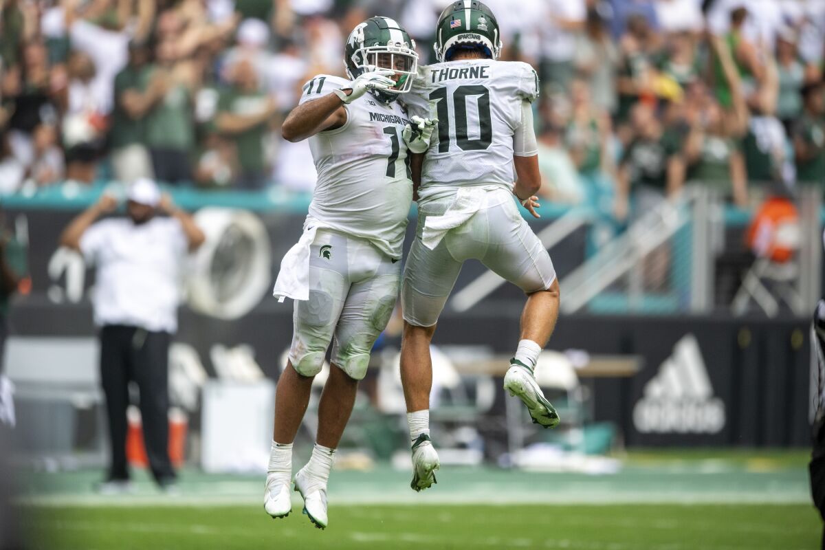 Michigan State running back Connor Heyward, left, and quarterback Payton Thorne celebrate a Spartans touchdown. 