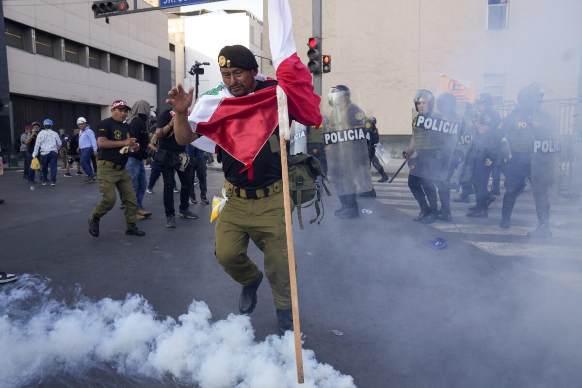 Un manifestante patea una lata de gas lacrimógeno durante una protesta contra el gobierno en Lima, 