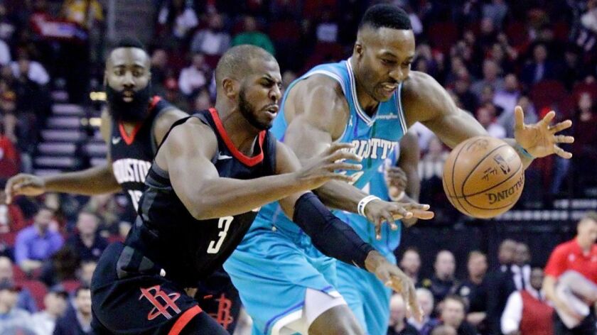 Houston Rockets guard Chris Paul (3) and Charlotte Hornets center Dwight Howard (12) chase a loose rebound during the first half on Wednesday.