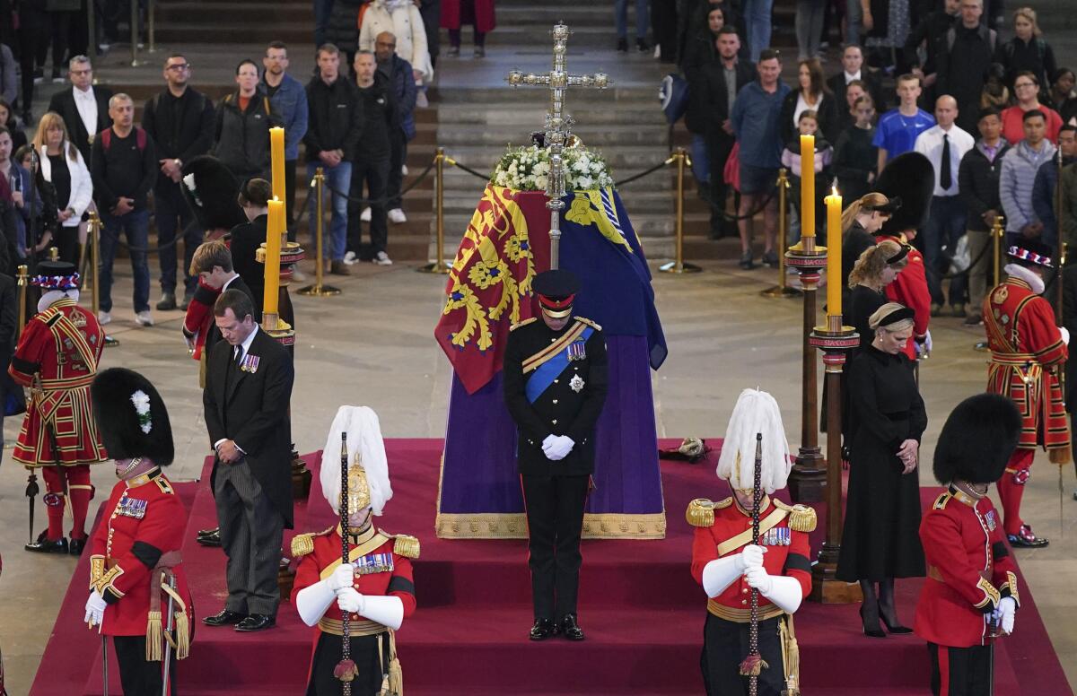 Queen Elizabeth II's grandchildren surround her coffin and bow facing outward during the vigil of the queen's grandchildren.