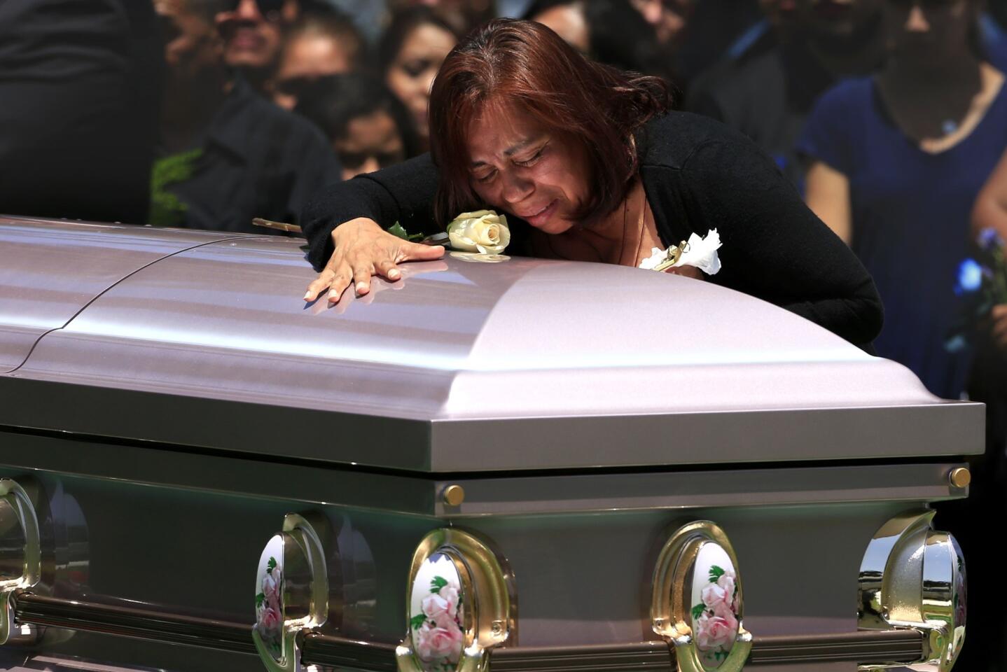 Macrina Reyes cries while she places a flower on the coffin of her transgender daughter, Zoraida Reyes, 28, during graveside services at Santa Ana Cemetery on June 23.