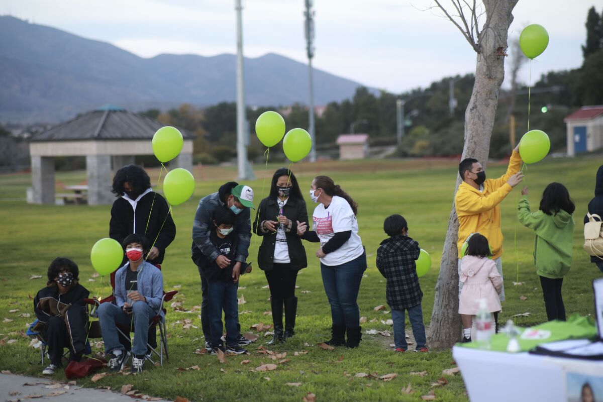 Family members and friends release balloons in honor of Maya Millete.