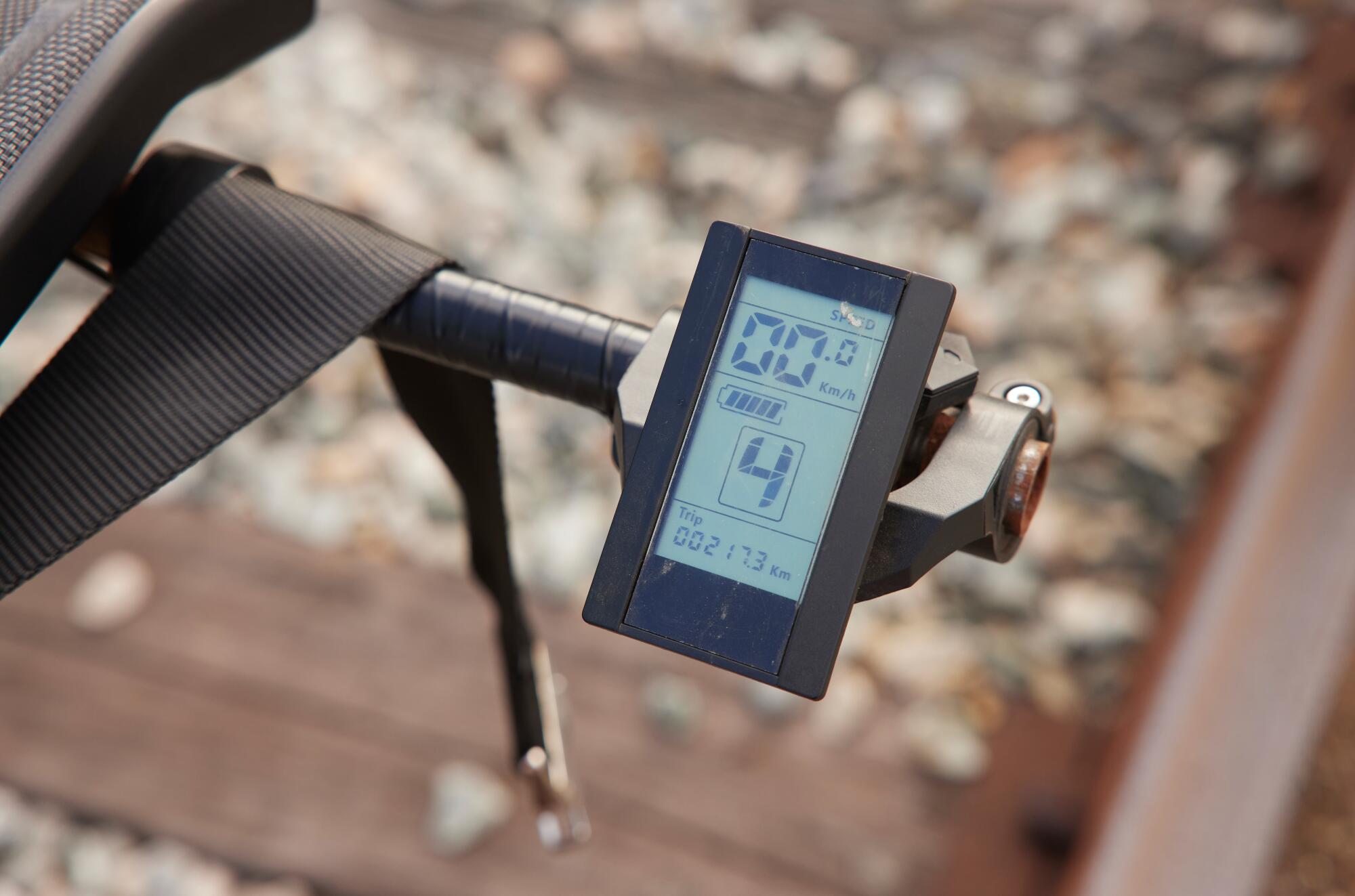A close-up of an electric screen attached to a railbike, showing battery status and distance travelled.