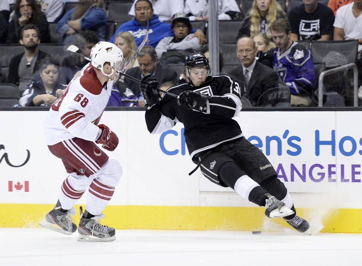 Kings forward Valentine Zykov, right, attempts to control the puck in front of Phoenix Coyotes defenseman James Melindy during a preseason game on Sunday.