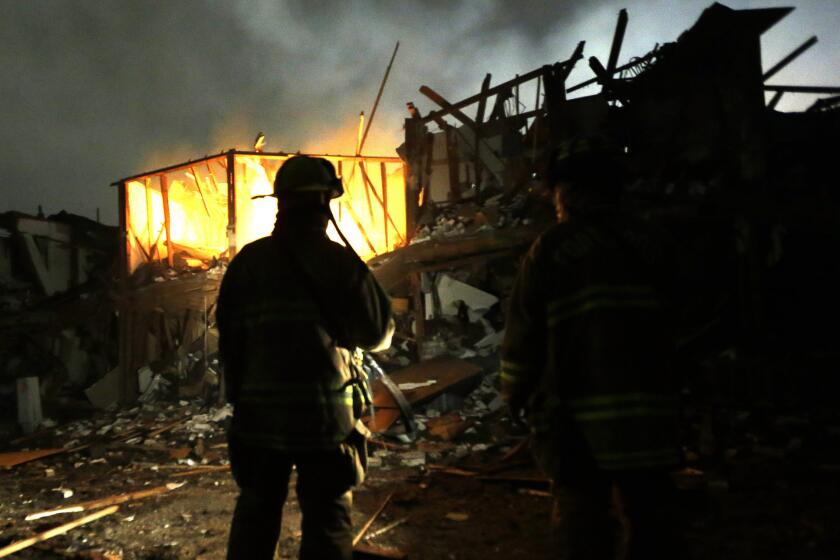 Firefighters search a destroyed apartment complex near the fertilizer plant that exploded in West, Texas, in April. OSHA has cited the plant's owner for 24 safety violations, including the unsafe handling and storage of chemicals, and has proposed $118,300 in penalties.