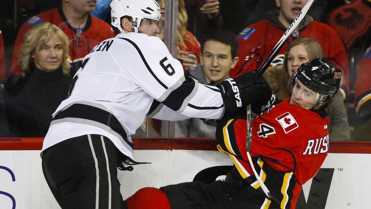 Kings defenseman Jake Muzzin (6) checks Flames defenseman Kris Russell during the third period Thursday night.