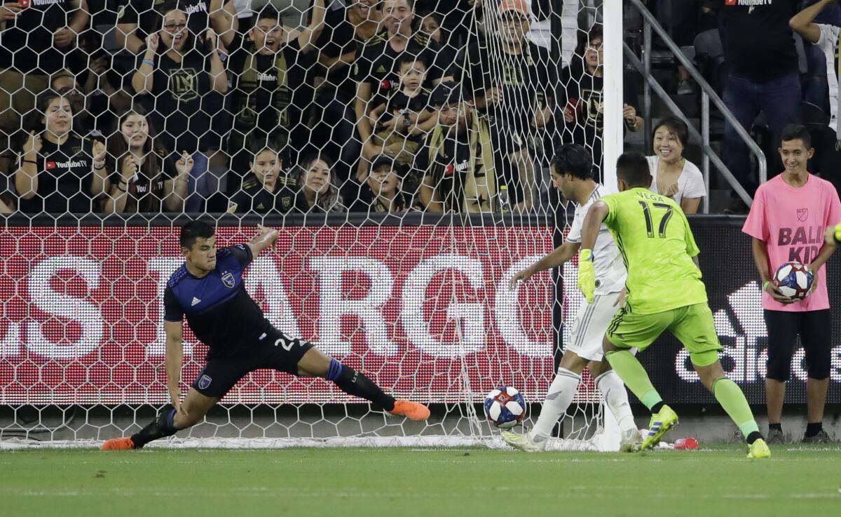 Los Angeles FC forward Carlos Vela, center, scores past San Jose Earthquakes goalkeeper Daniel Vega (17) and defender Nick Lima during the first half of an MLS soccer match Wednesday, Aug. 21, 2019, in Los Angeles. (AP Photo/Marcio Jose Sanchez)