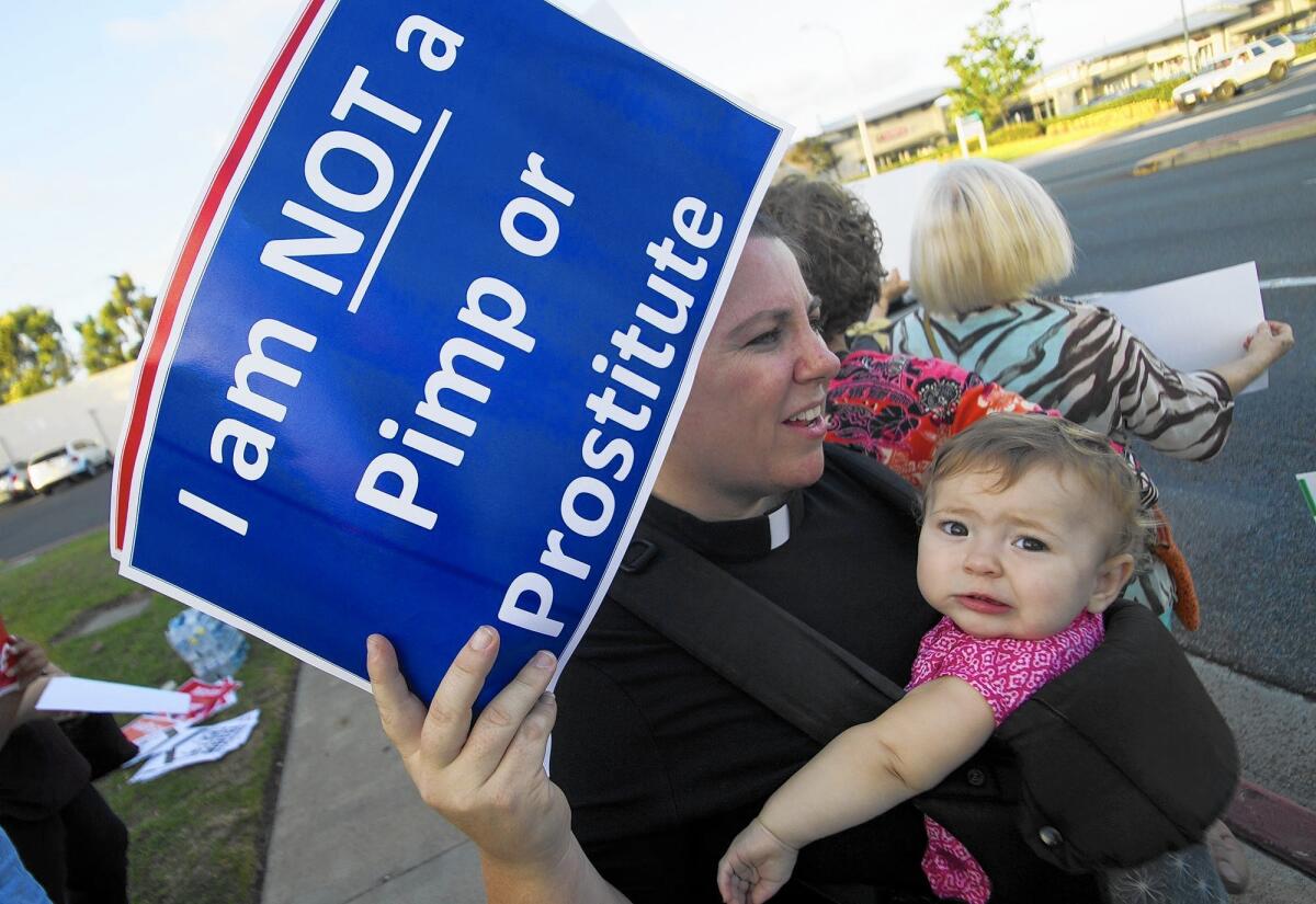 The Rev. Sarah Halverson-Cano and her daughter Mollie join a protest in front of the Costa Mesa Motor Inn on Oct. 22.The City Council approved plans to demolish the motel and replace it with high-end apartments.