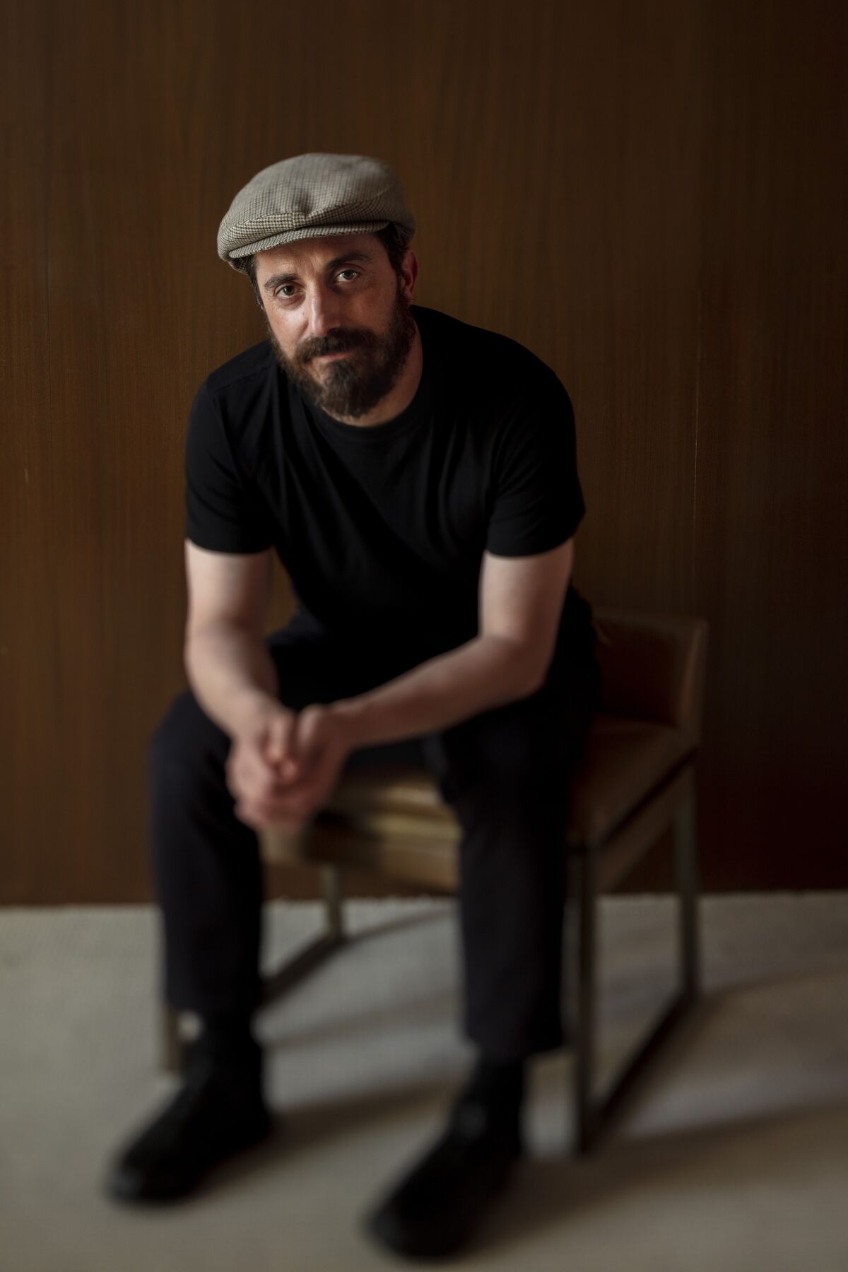 Director Pablo Larrain sits hands clasped for a portrait