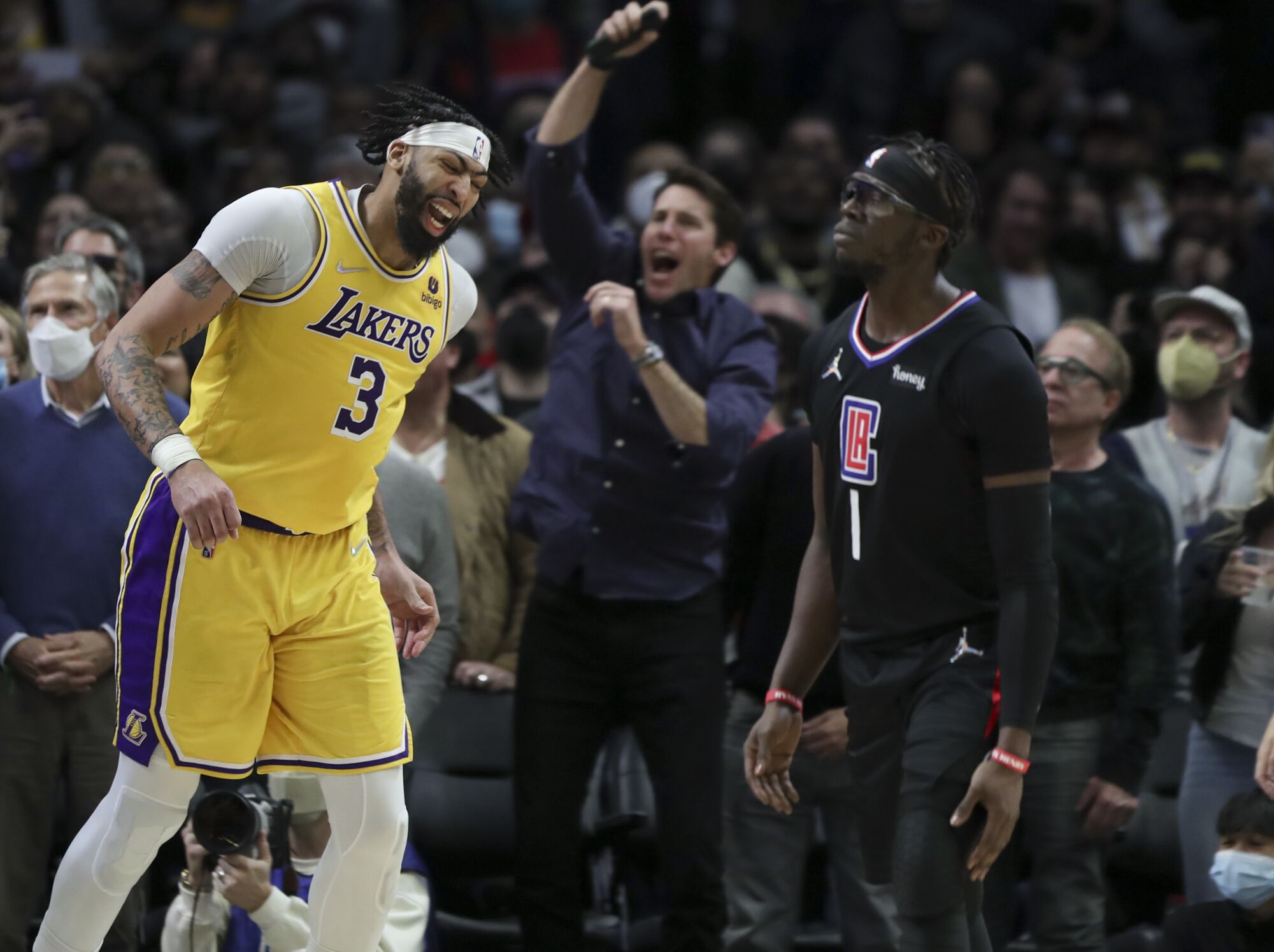 Lakers' Anthony Davis reacts after missing the potential game-winning shot while Clippers' Reggie Jackson appears satisfied.