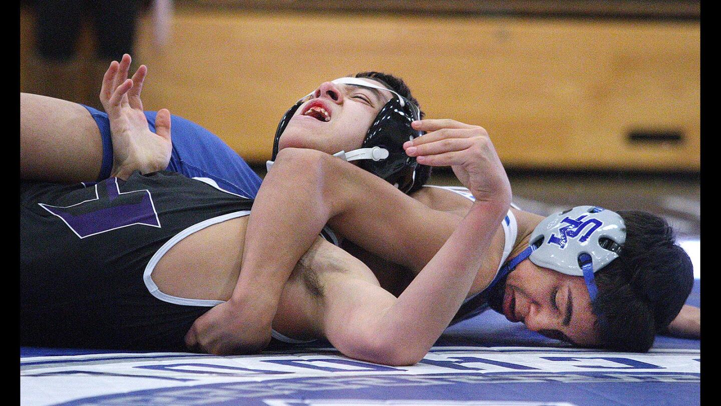 Hoover's Arthur Harutyunyan grimmaces as he is rolled onto his back by San Marino's Beau Perez in the 120 pound bout in a Rio Hondo League wrestling match at San Marino High Schoolon Tuesday, Feb. 2, 2016. San Marino won the match 58-19