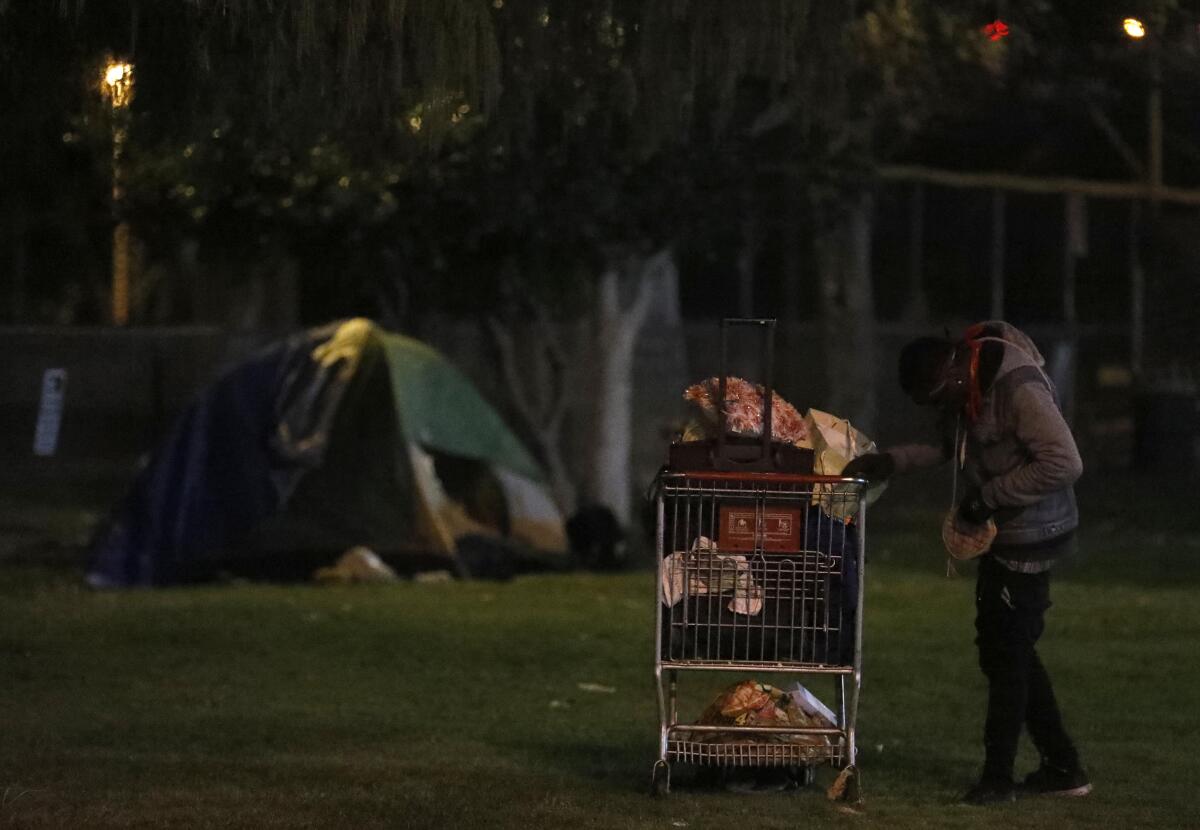 A homeless person stands with his belongings on the first night of this year's L.A. County homeless count in North Hollywood.