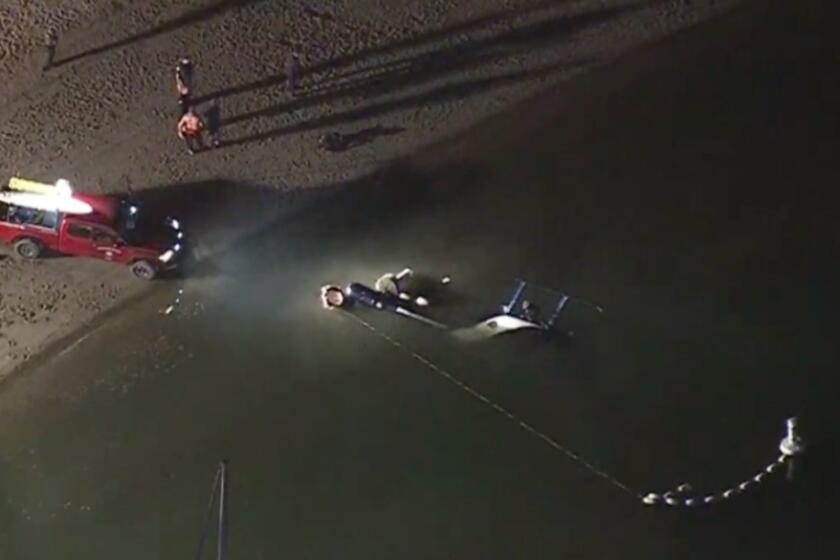A Huntington Beach Police Department helicopter crashed into the water in Newport Beach Saturday in front of dozens of witnesses lining the beach. Both pilots were transported to a local trauma center. MANDATORY CREDIT: CBS2/KCAL9