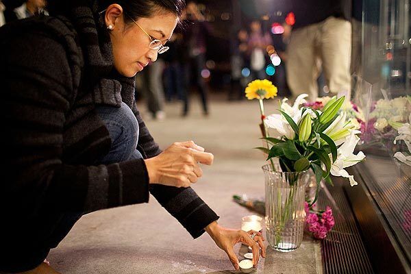 Surina Shukri lights a candle in remembrance of Steve Jobs outside an Apple Store in New York.