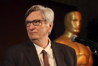 With a giant Oscars statue behind him, film academy President John Bailey speaks at an Oscars luncheon in 2019.