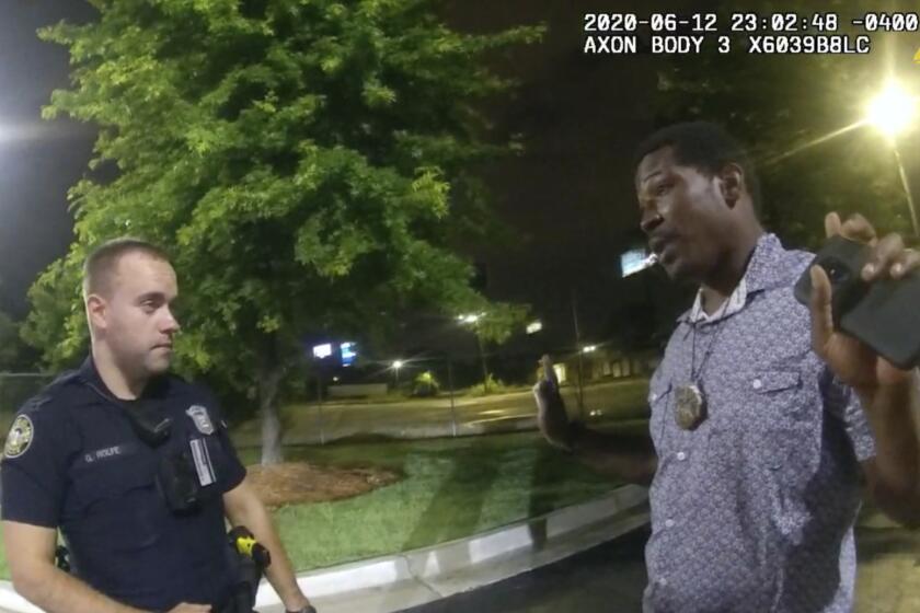 FILE - This screen grab taken from body camera video provided by the Atlanta Police Department shows Rayshard Brooks speaking with Officer Garrett Rolfe, left, in the parking lot of a Wendy's restaurant, late Friday, June 12, 2020, in Atlanta. Rolfe, who fatally shot Rayshard Brooks in the back after the fleeing man pointed a stun gun in his direction, was charged with felony murder and 10 other charges, announced Wednesday, June 17, 2020. Rolfe was fired after the shooting. (Atlanta Police Department via AP)