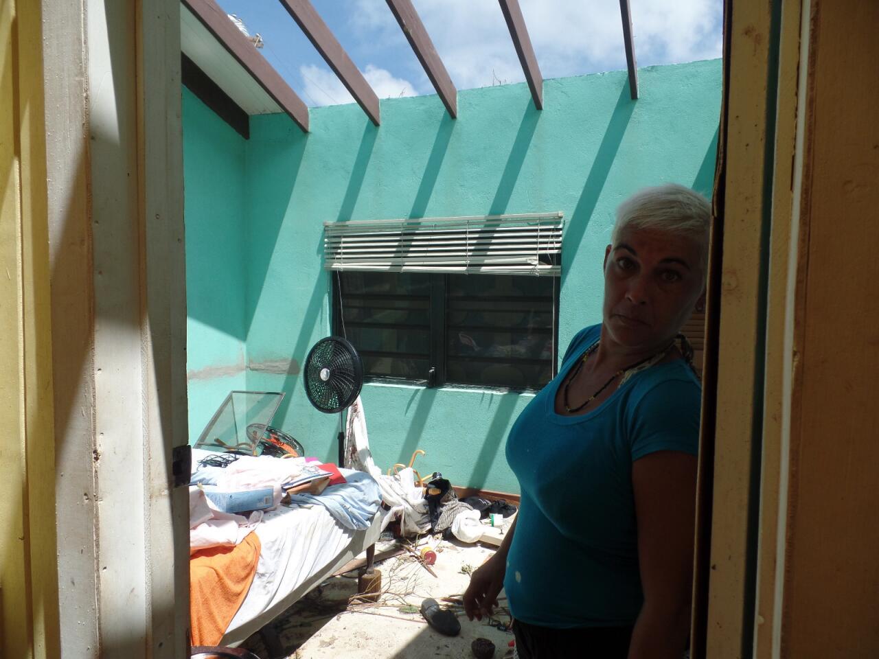 A woman stands at her home damaged by Hurricane Irma in Codrington, Antigua and Barbuda, on Sept. 9, 2017.