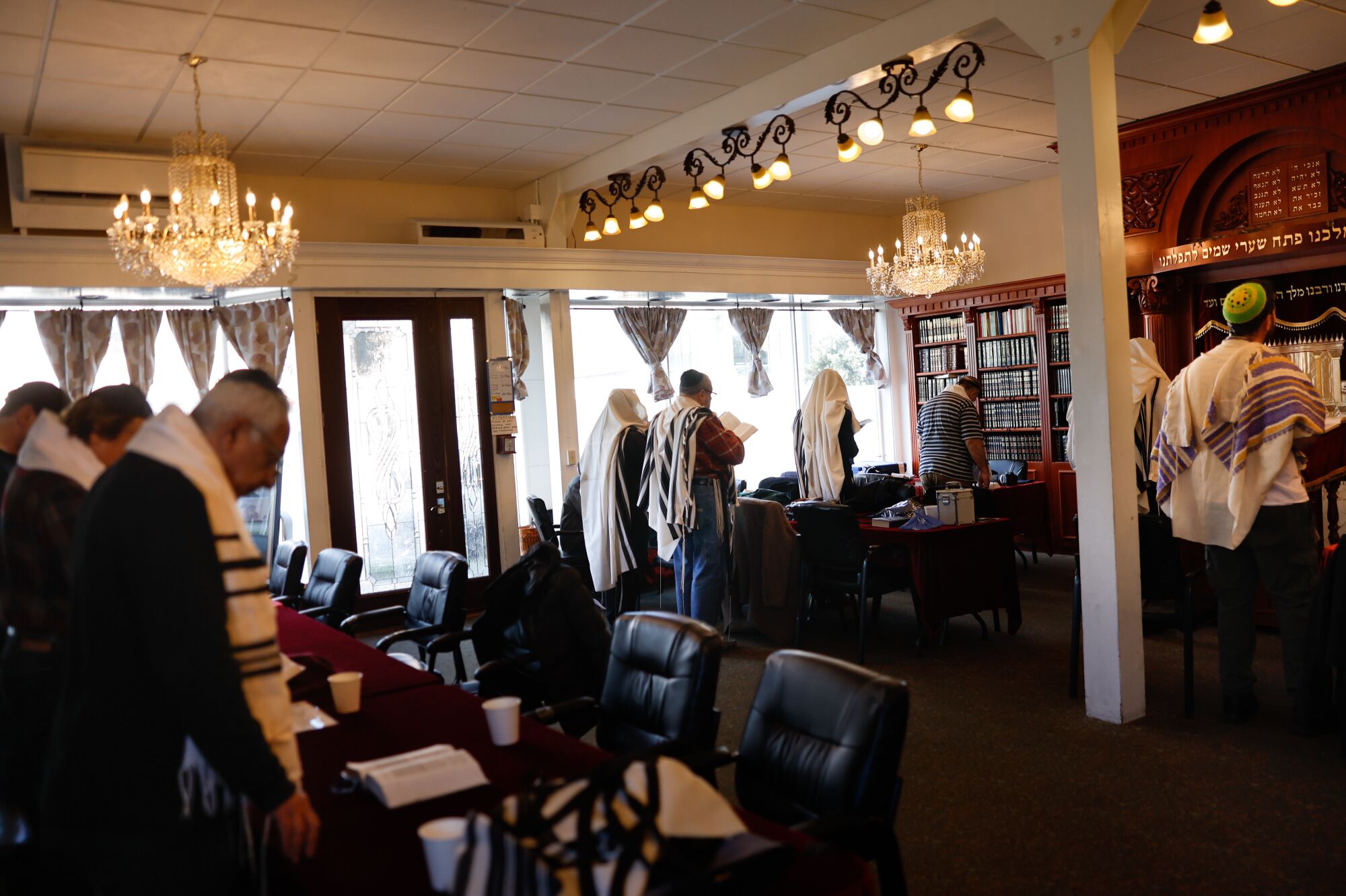 Cemaatler Schneerson Yahudi Merkezi'nde ibadet ederken başlarını eğiyor.