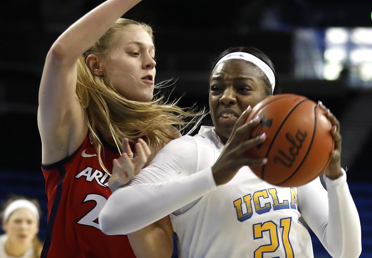 UCLA’s Michaela Onyenwere, right, drives to the basket in front of Arizona’s Cate Reese during the Bruins' win Sunday.