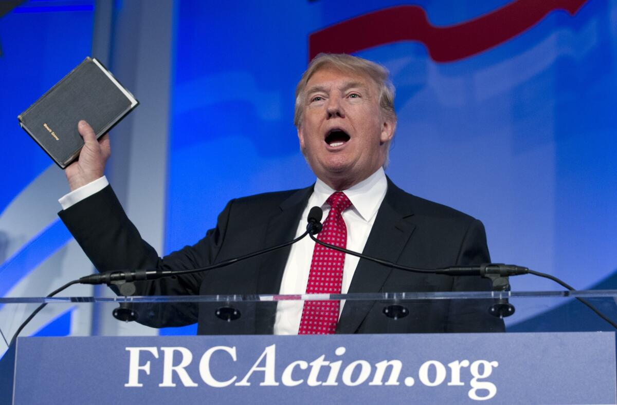 Republican presidential candidate, businessman Donald Trump, holds up his bible who was giving to him by his mother as he speaks during the Values Voter Summit, held by the Family Research Council Action, Friday, Sept. 25, 2015, in Washington ( AP Photo/Jose Luis Magana)