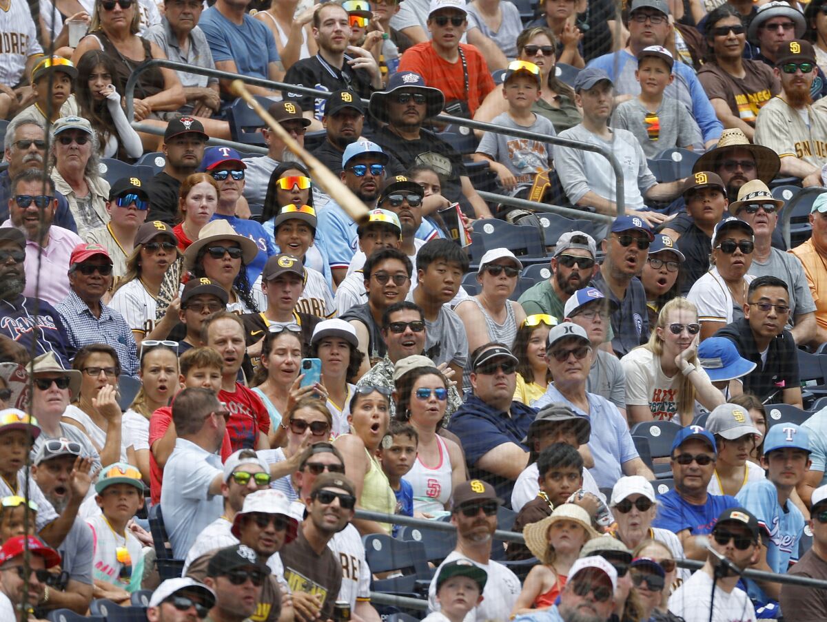 SAN DIEGO, CA - JULY 30: Fans watch a flying bat San Diego Padres let go while swinging against the Texas Rangers at Petco Park on Sunday, July 30, 2023. (K.C. Alfred / The San Diego Union-Tribune)
