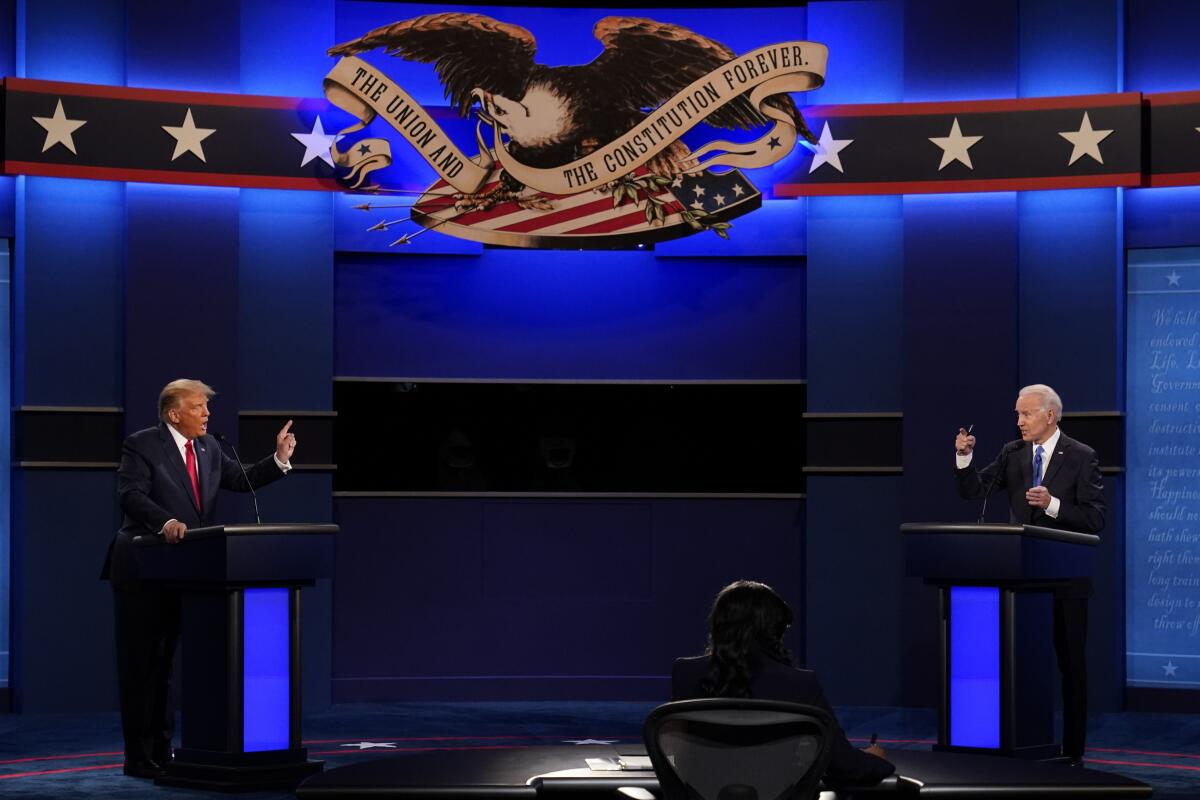 Donald Trump and Joe Biden face and gesture at each other during a debate in 2020.
