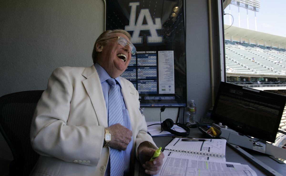 Dodgers announcer Vin Scully laughs inside his booth at Dodger Stadium before the start of a game.