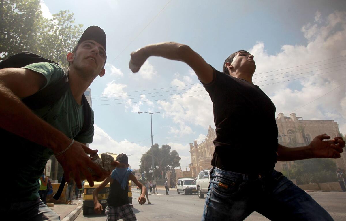 Palestinian youths throw stones Sept. 21 during clashes against Israeli security forces over the flashpoint Al Aqsa mosque compound at the main entrance of the West Bank city of Bethlehem.
