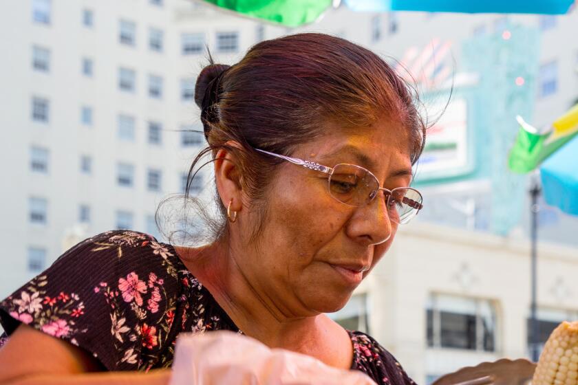 Clara Estrada Vasquez prepares an elote