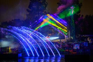 Colorful lights and projection effects illuminate a show scene between Mickey Mouse and Maleficent. 