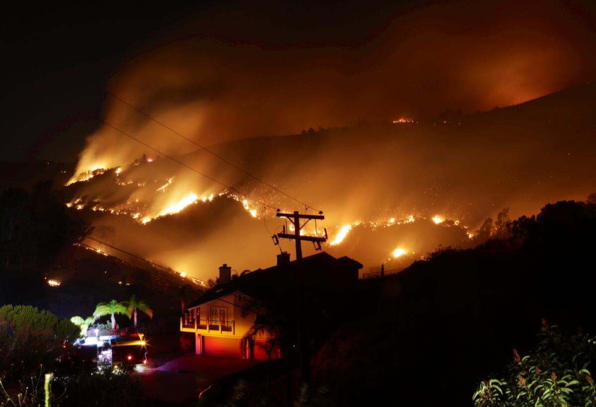 Flames were threatening homes in San Marcos Wednesday night as wildfires raged in San Diego County.