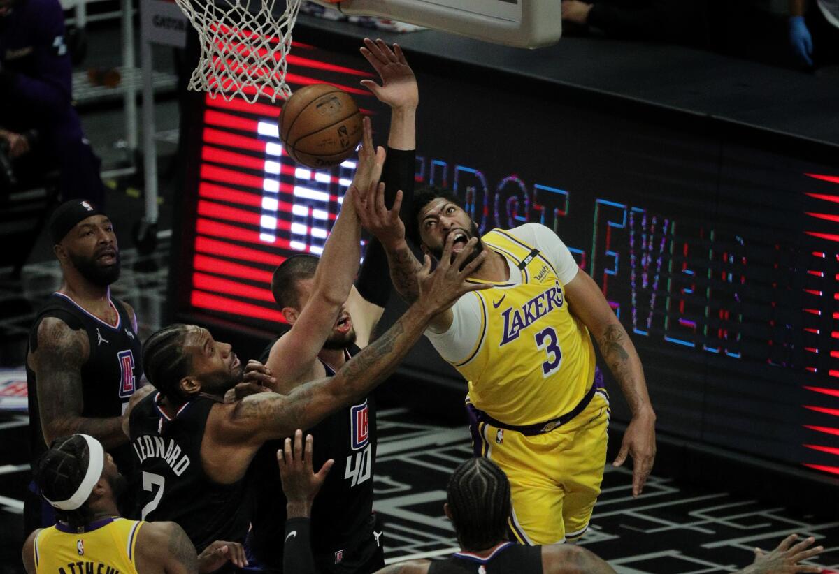 Lakers forward Anthony Davis tries a reverse lay-up, but runs in to the defense of the Clippers.