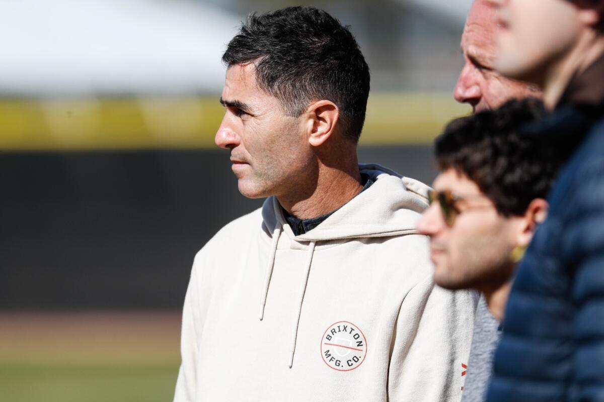 AJ Preller watches players during a 2023 spring training workout in Peoria, Ariz.