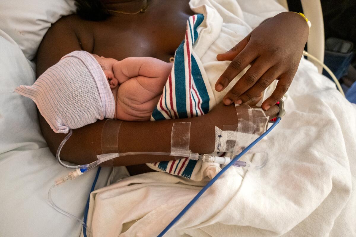 A woman holds her newborn baby boy.