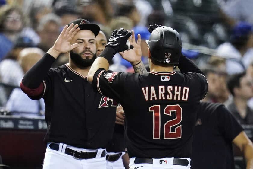 Arizona Diamondbacks' Daulton Varsho (12) celebrates his home run against the Los Angeles Dodgers with Emmanuel Rivera during the first inning of a baseball game in Phoenix, Wednesday, Sept. 14, 2022. (AP Photo/Ross D. Franklin)