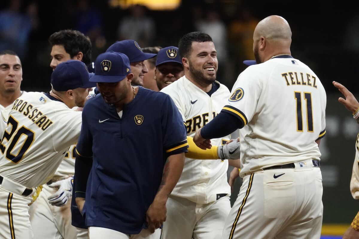 Milwaukee Brewers' Victor Caratini, second from right, is congratulated by teammates after his two-run single during the 11th inning of the team's baseball game against the Los Angeles Dodgers on Tuesday, Aug. 16, 2022, in Milwaukee. The Brewers won 5-4. (AP Photo/Aaron Gash)