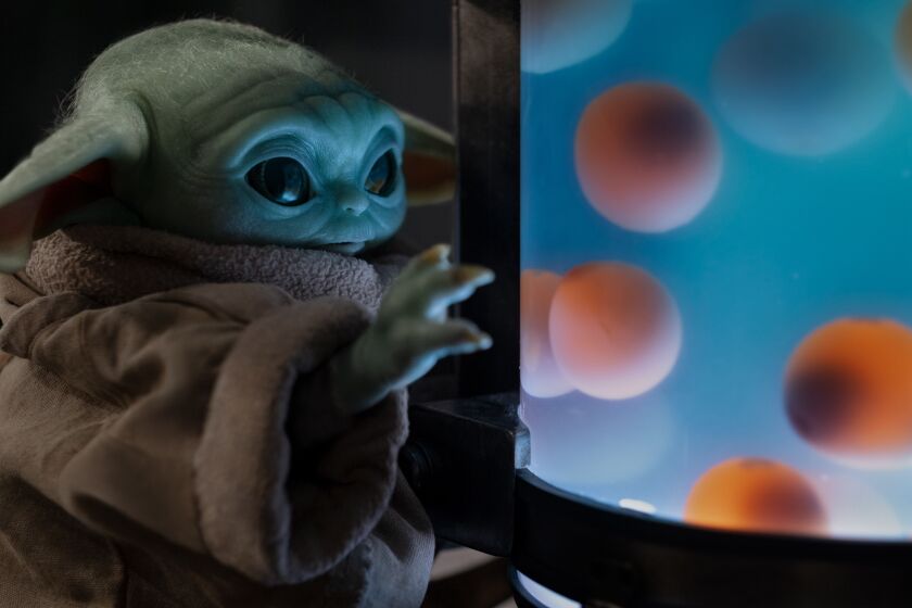 Baby Yoda stares at a tank of eggs