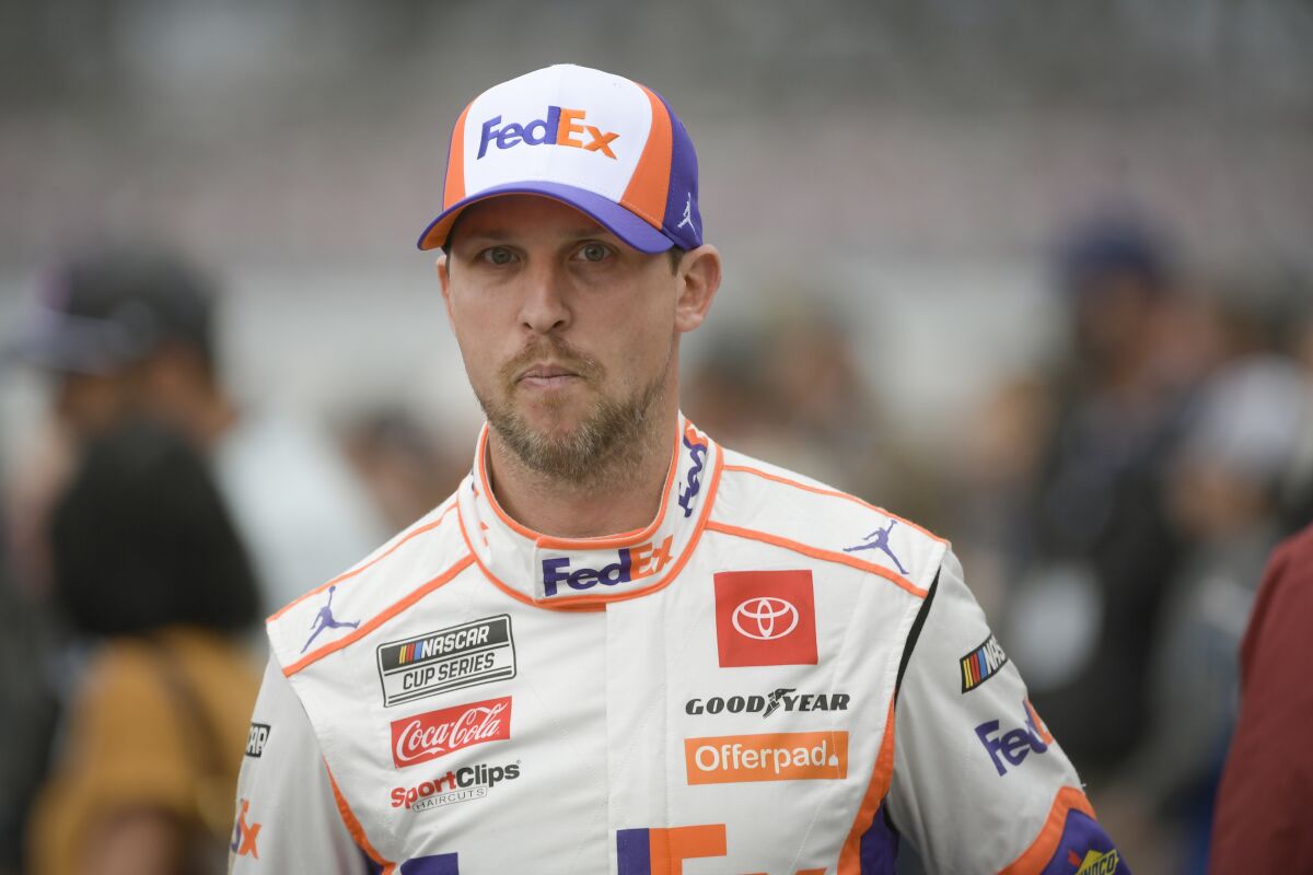 Denny Hamlin makes his way to his car for a NASCAR Cup series auto race Sunday, Oct. 3, 2021, in Talladega, Ala. The race was postponed until Monday due to wet weather. (AP Photo/John Amis)