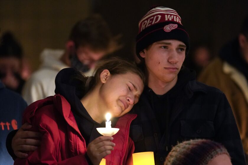People attending a vigil embrace at a church in Michigan after the school shooting.
